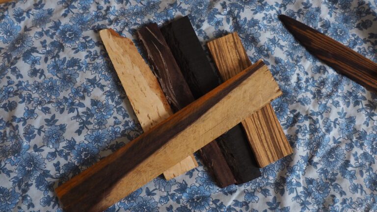 Photo de différentes essences de bois aux couleurs très variées. Une des pièces ressemble à du nougat. Une autre est noire d'encre (de l'ébène). Une autre à des rayures..